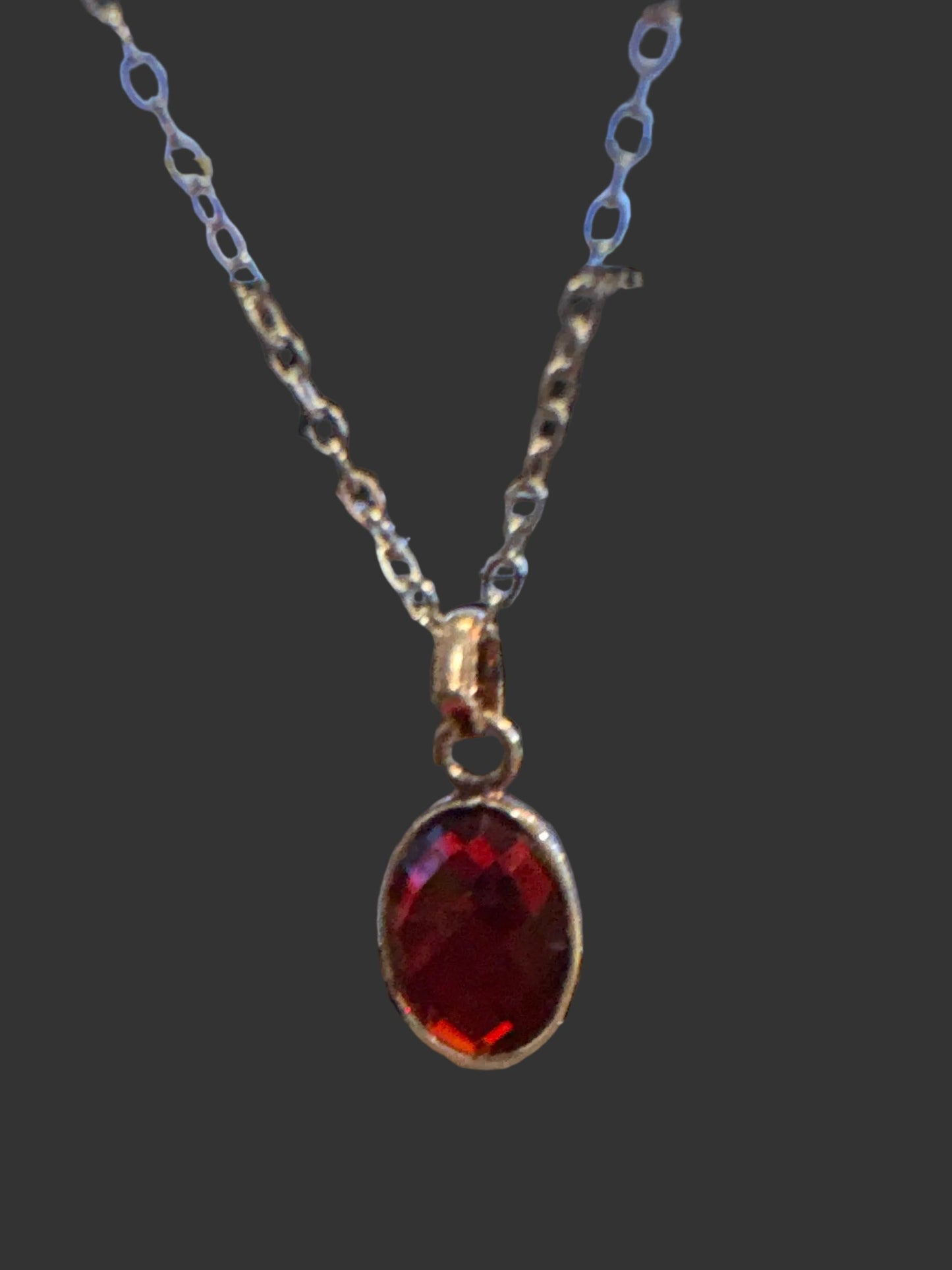 Faceted oval garnet secured in a classic bezel
