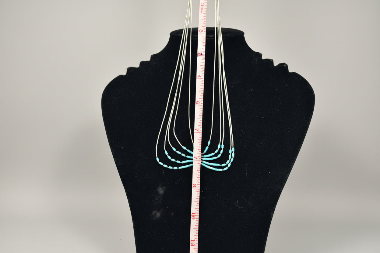 Necklace displayed on a mannequin bust with a measuring tape for scale.