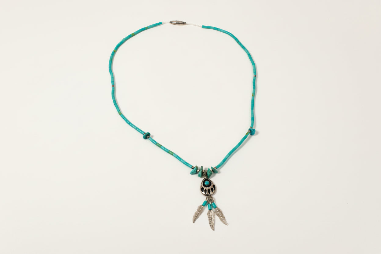 Turquoise necklace with silver clasp on a light gray background