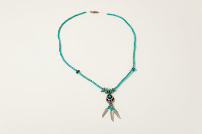 Turquoise necklace with silver clasp on a light gray background