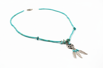 Turquoise leather necklace with metal charms on a white background