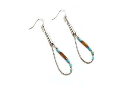 Earrings with decorative beads on a light gray background