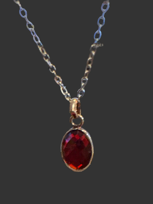 Faceted oval garnet secured in a classic bezel