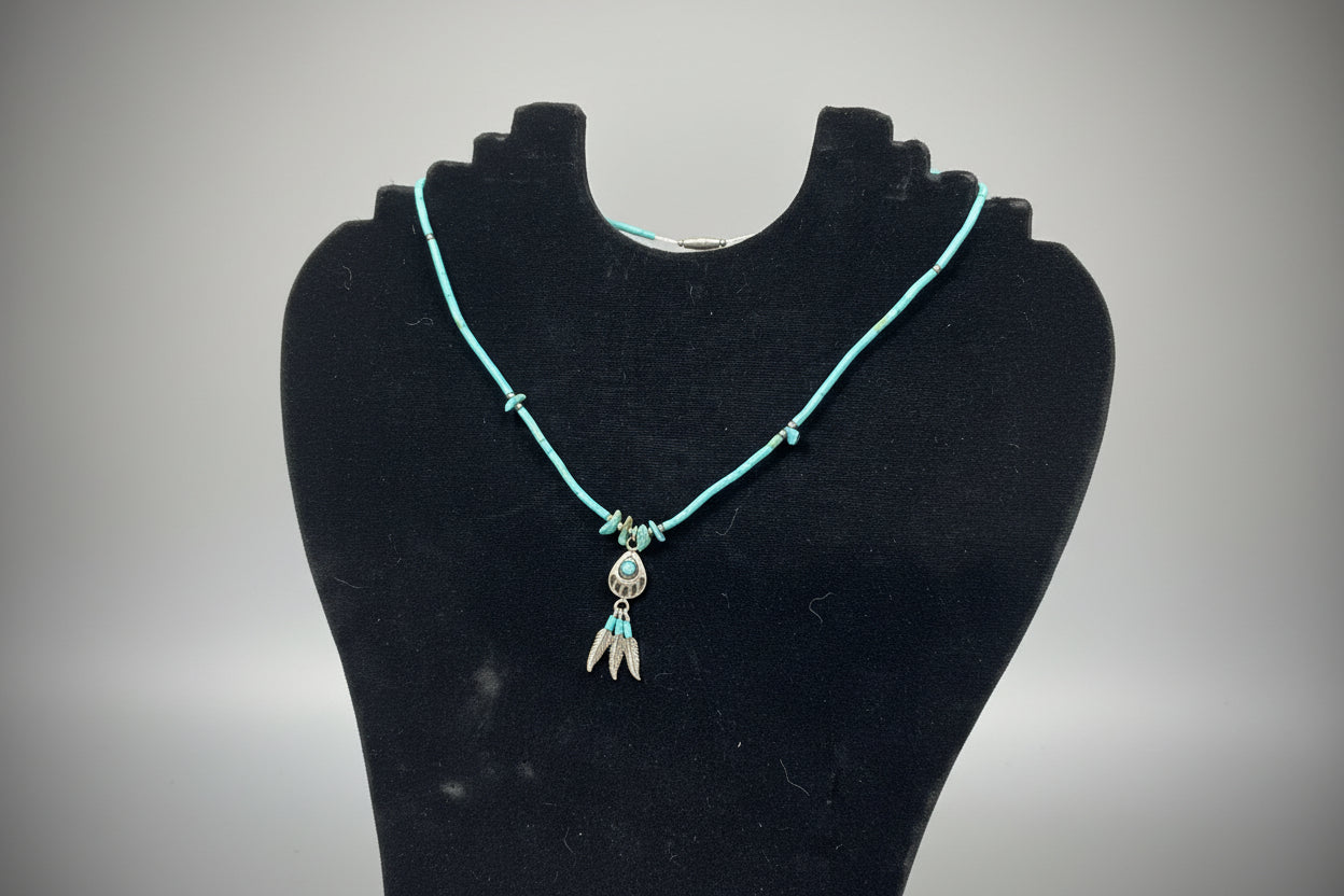 Turquoise beaded bracelet with a decorative clasp on a black stand.