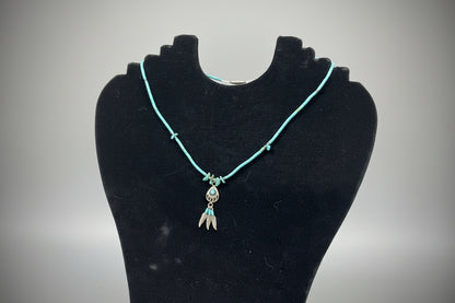 Turquoise beaded bracelet with a decorative clasp on a black stand.