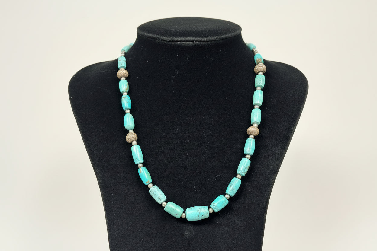 Turquoise beaded necklace on a black display stand