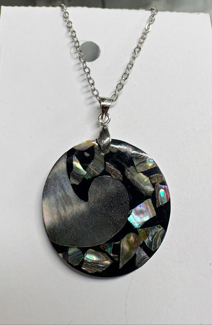 Necklace with a round pendant on a white card against a blurred background