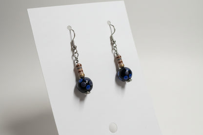 Pair of earrings with a black gemstone on a white card