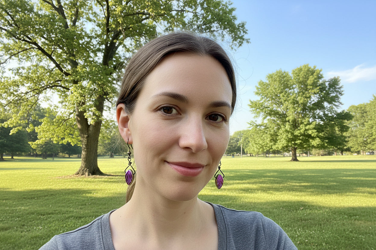 Pair of earrings with purple and gold design on a white surface