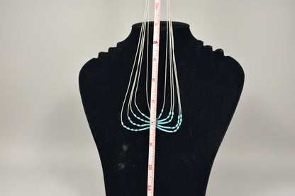 Necklace displayed on a mannequin bust with a measuring tape for scale.