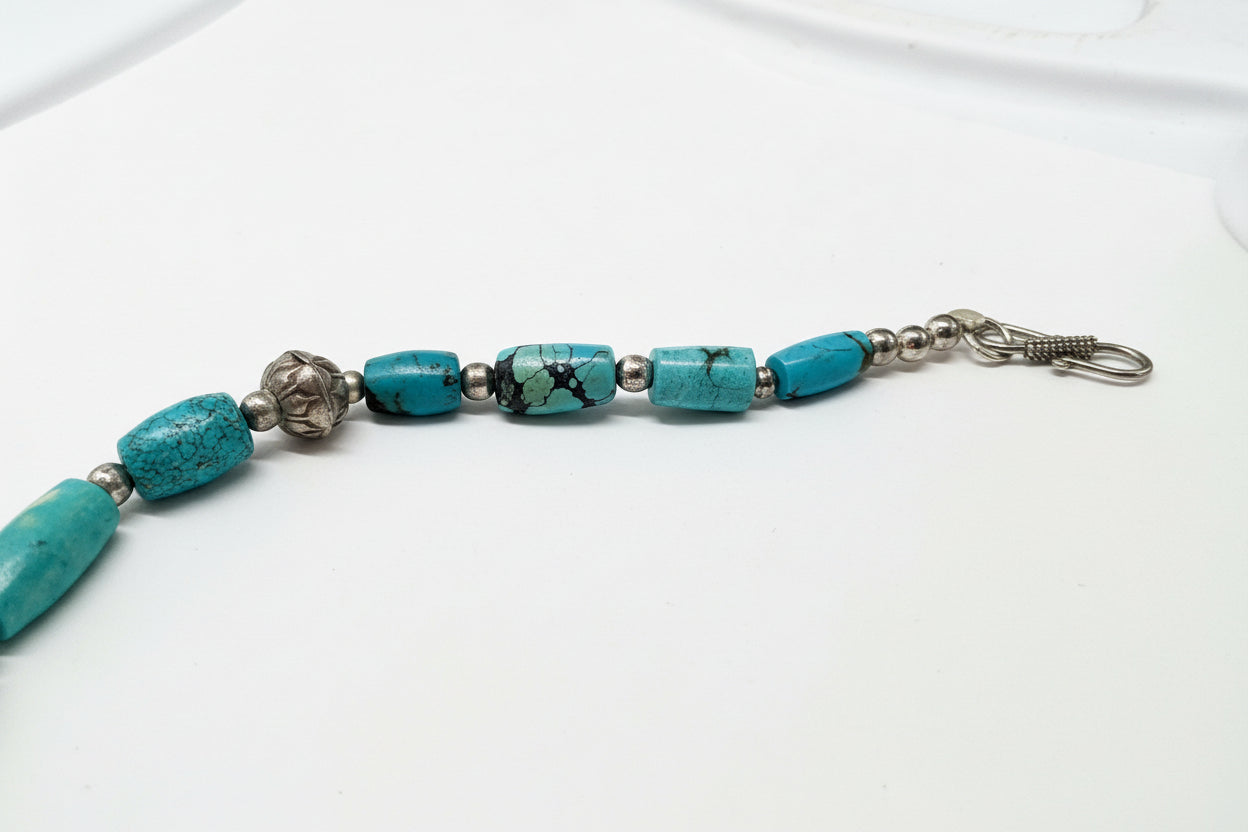 Bracelet with turquoise beads and metal clasps on a measuring tape