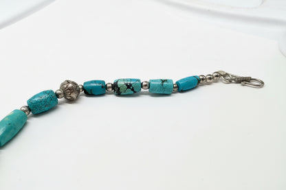 Bracelet with turquoise beads and metal clasps on a measuring tape