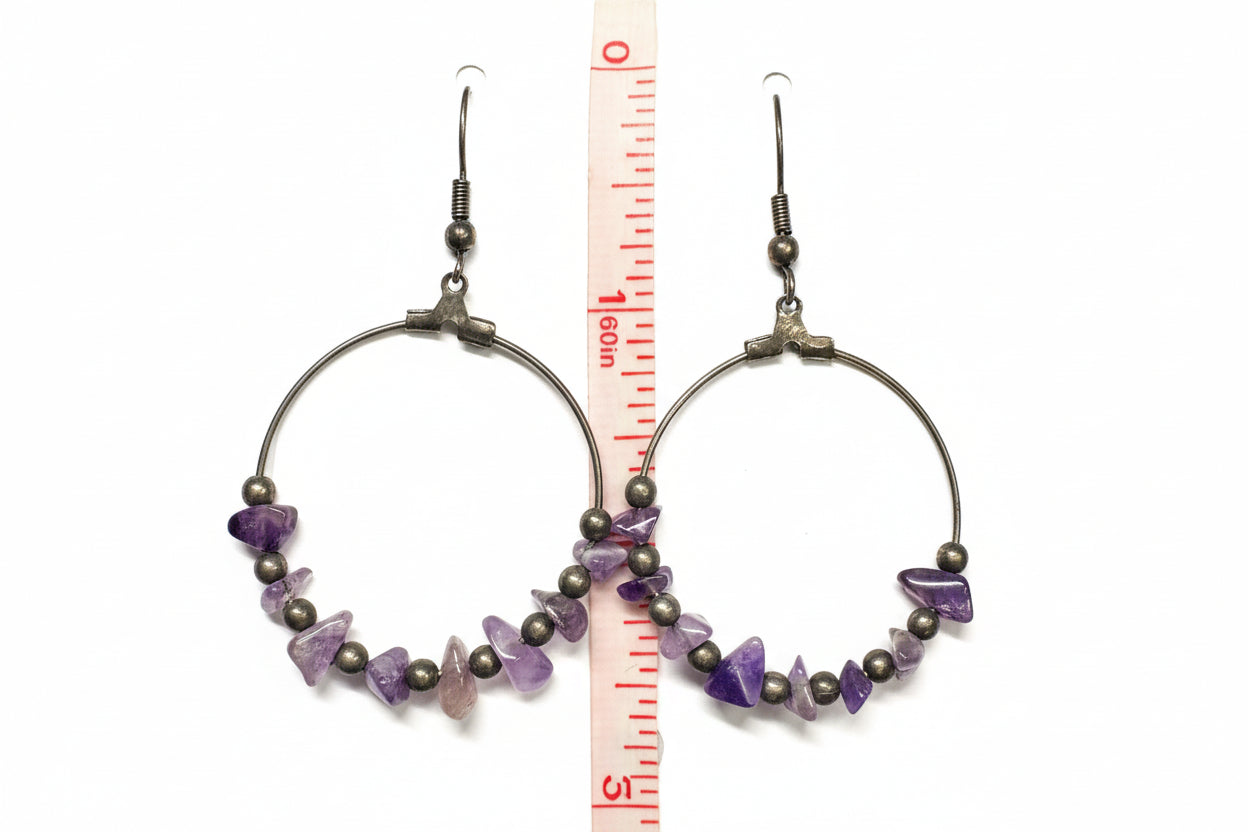 ameythist gemstones on a hoop dropped by a hook with a ruler for scale.