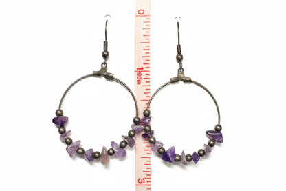 ameythist gemstones on a hoop dropped by a hook with a ruler for scale.