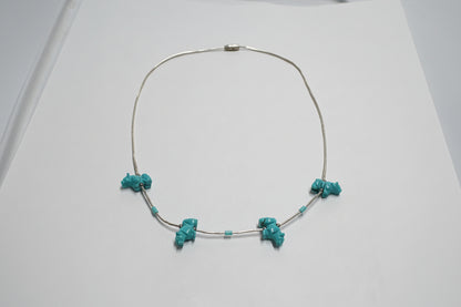Necklace with turquoise beads on a light gray background