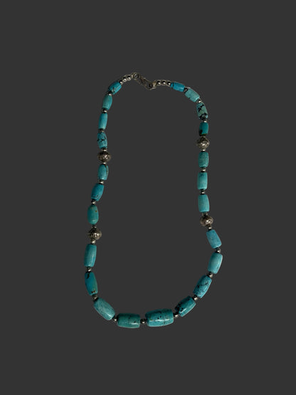 Necklace with turquoise beads on a white tray