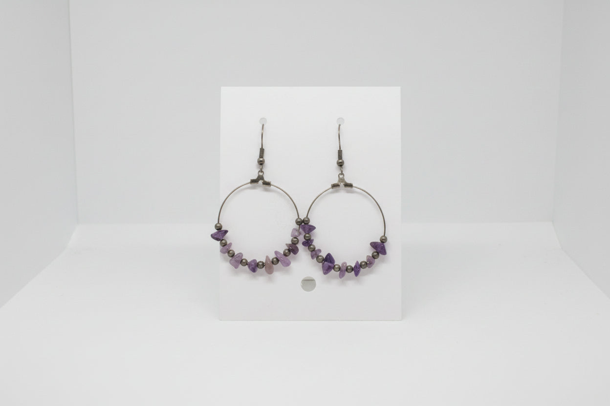 card with hoop earrings on a plain background