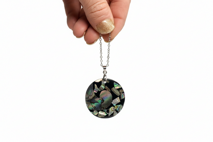 Necklace with a circular pendant being measured against a ruler