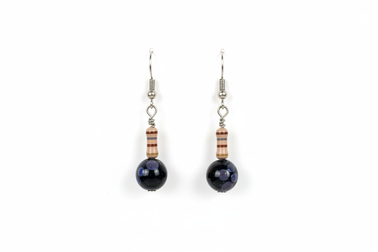 Pair of earrings with dark beads on a white card