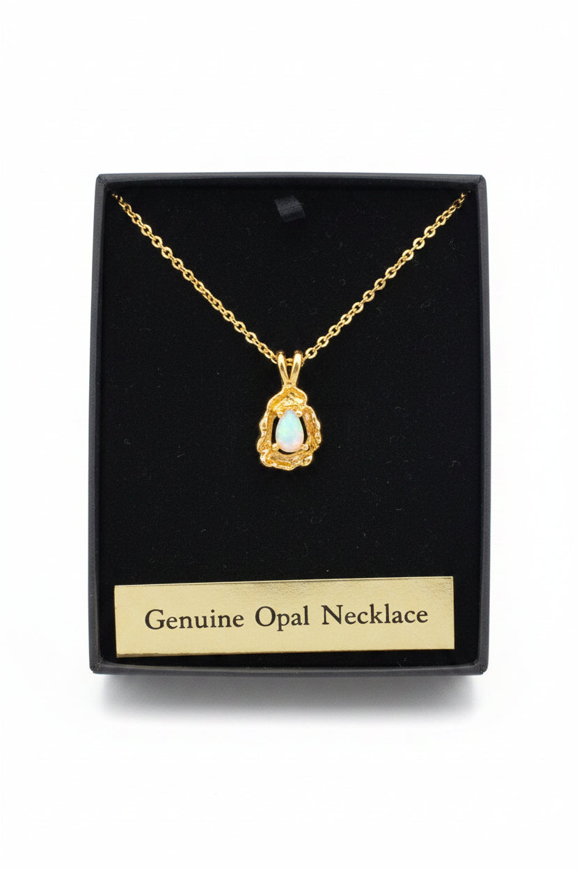 Gold necklace with a pendant on a black card labeled 'Genuine Opal Necklace' next to a bottle of water.