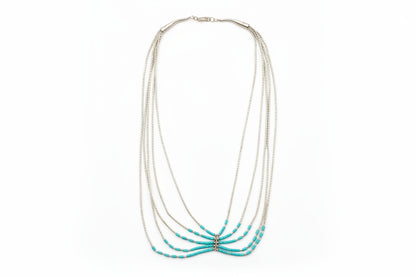 Necklace with turquoise beads on a light gray background