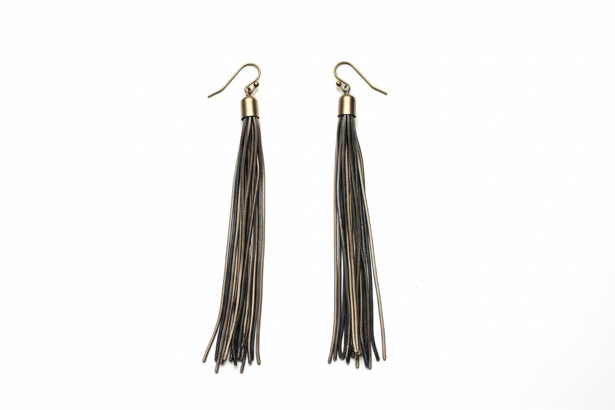 Pair of black tassel earrings on a gray background