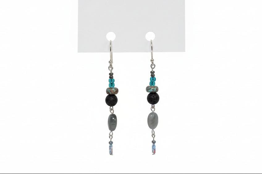 Pair of beaded earrings on a white card with a brand logo.