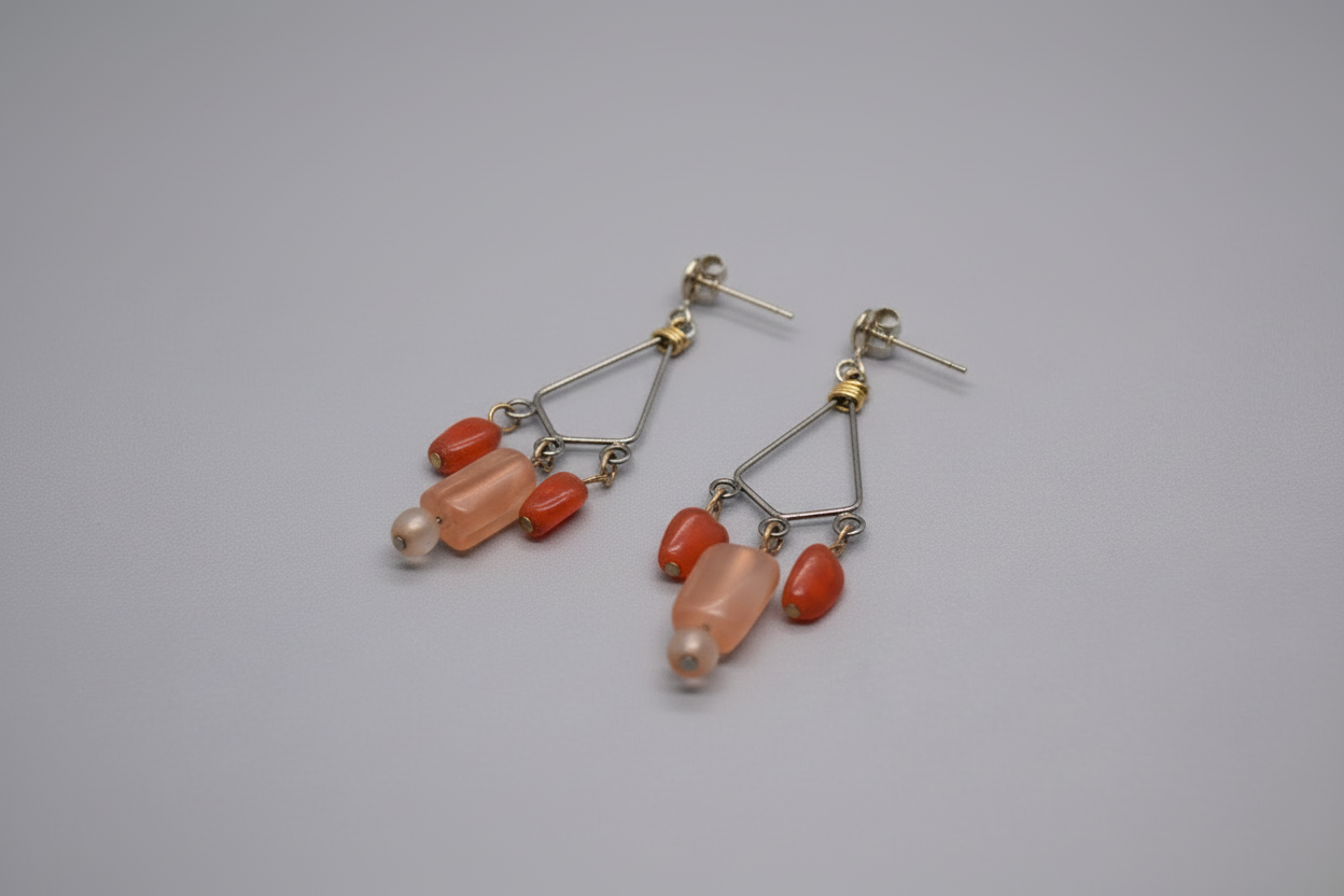 Pair of earrings with pink and orange beads on a gray background