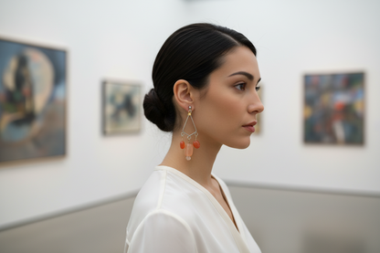 Pair of earrings with pink and orange beads on a gray background