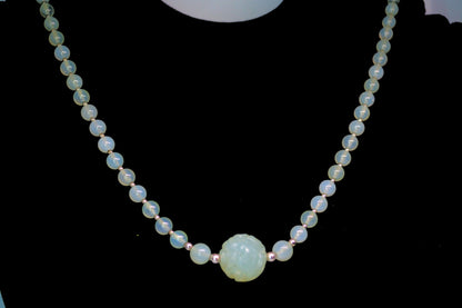 Necklace with light blue beads on a black background