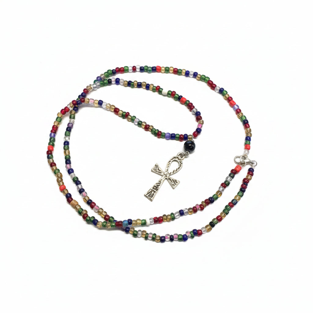 Colorful beaded necklace with a ankh pendant on a laptop surface