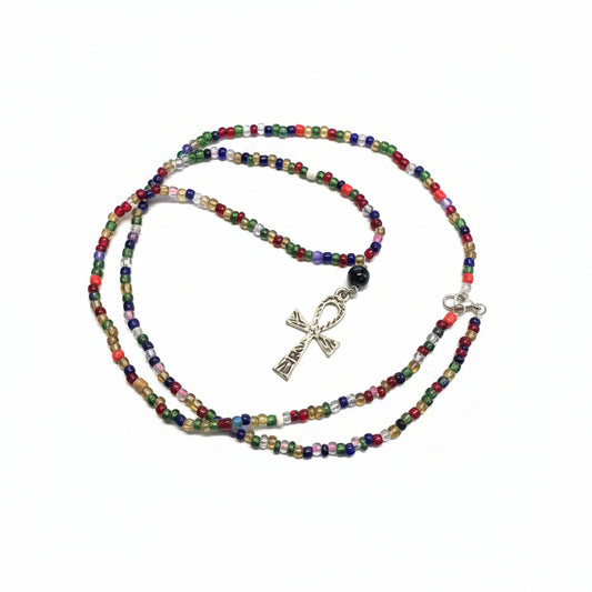 Colorful beaded necklace with a ankh pendant on a laptop surface